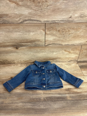 Kids denim jacket with long sleeves and button front on wood background