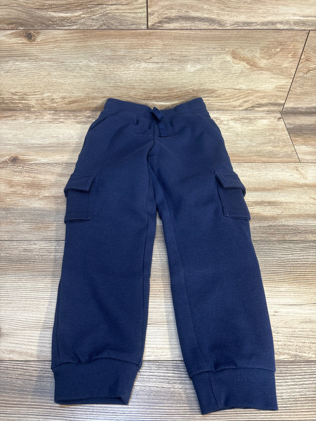 Navy blue kids cargo joggers with drawstring waist, laid flat on wood floor