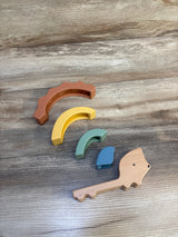 Top-down view of Cloud Island Silicone & Wood Hedgehog Stacker showing four colorful silicone arches and wooden hedgehog base on wood surface