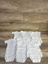 Front view of Huggies 6-pack white baby bodysuits showing lap shoulder necks and snap crotch closures on wood plank background