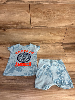 Baby outfit with blue tie-dye shorts and Captain America themed T-shirt on wooden floor