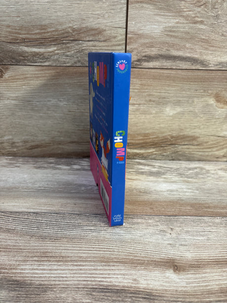 Side view of Sensory Snuggables Chomp! board book showcasing colorful vertical “CHOMP!” spine with wood plank background