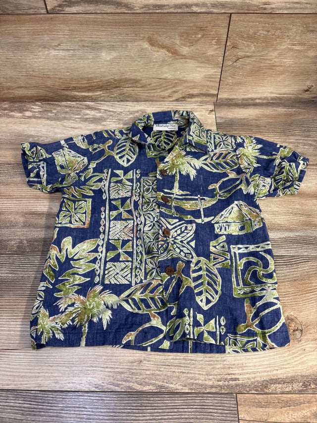 Flat lay of blue Bishop St. Hawaiian short sleeve toddler shirt (size 5T) showcasing green palm and tiki print on a wood background