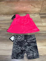 Flat-lay of 12M hot pink Nike Dri-FIT tank and gray patterned Dri-FIT shorts, front view with tags on wood background