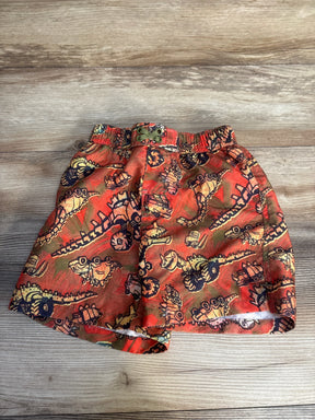 Red boys' shorts with fun dinosaur and vehicle cartoon print on wood background