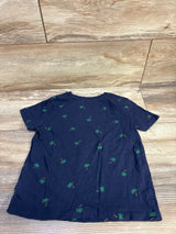 Back view of Old Navy navy toddler t-shirt showcasing all-over green palm tree print and short sleeves, laid flat on a wood floor