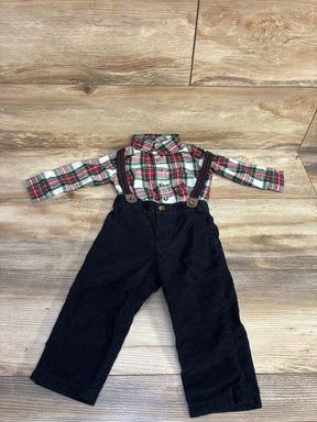 Toddler outfit with red and green plaid shirt and black corduroy pants with suspenders on wood floor