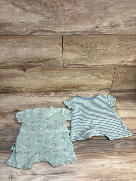 Two baby rompers on wood floor, one with dinosaur print, one with blue stripes