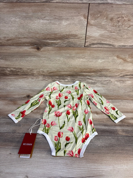 Floral tulip print baby onesie with long sleeves, soft fabric, and brand tag on wooden floor