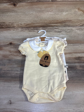 Front view of Rabbit and Bear organic 3-pack baby bodysuits in pale yellow and neutrals, showing collar and snap closures on wood background
