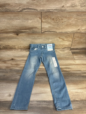 Light blue kids' jeans with tags on wooden background, gently used children's clothing