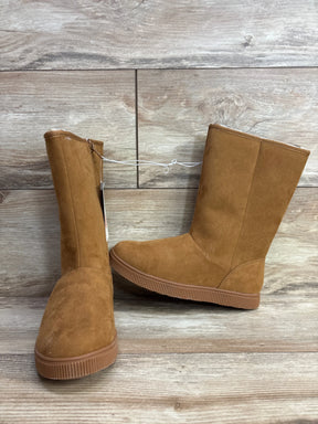 Kids brown suede winter boots with flat rubber soles on wood floor