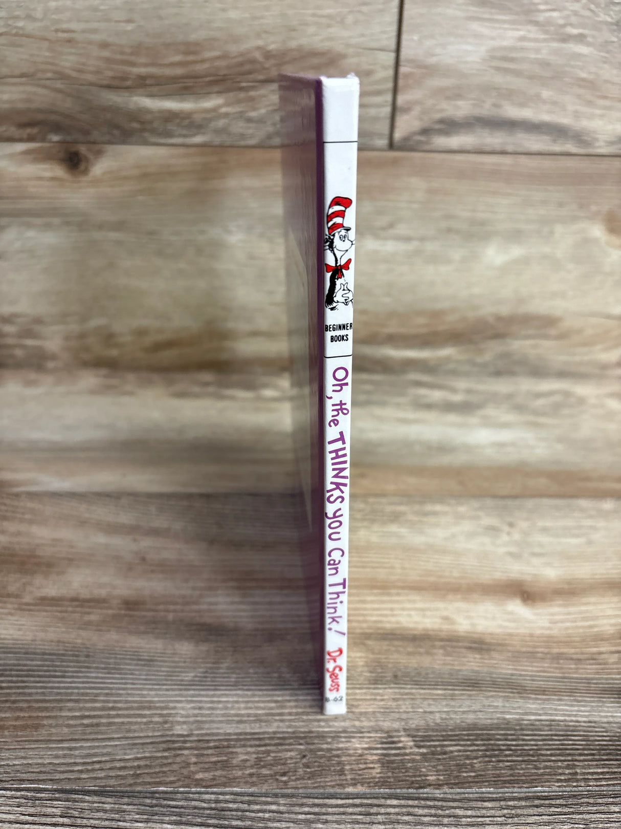 Spine of Dr. Seuss's children's book Oh, the THINKS You Can Think! standing on wooden surface