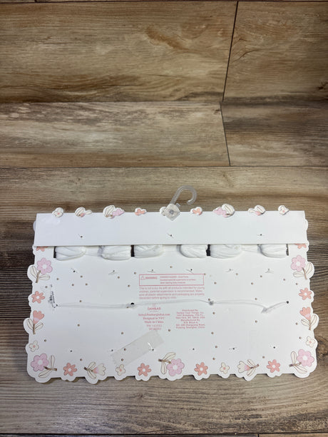 Back view of Ava & Olivia six-piece headwrap and bootie set showing white accessories on a floral display card
