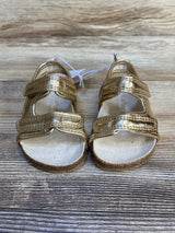 Front of Just One You First Walker sandals, gold, size 3C, showing double Velcro straps and cork footbed on wood floor
