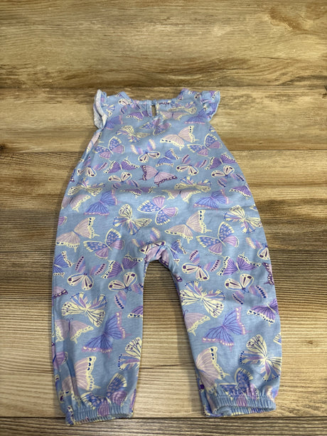 Flat lay of purple butterfly-print baby romper showing flutter sleeves and elasticized ankle cuffs on wood background