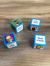 Angled view of Lakeshore Calm Down Cubes with prompts Draw a picture, Drink water, Hug a toy, Read a book on wood tabletop