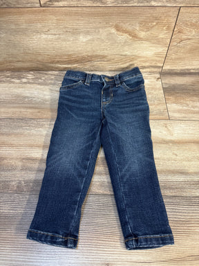 Dark wash denim jeans for toddlers displayed on wooden background