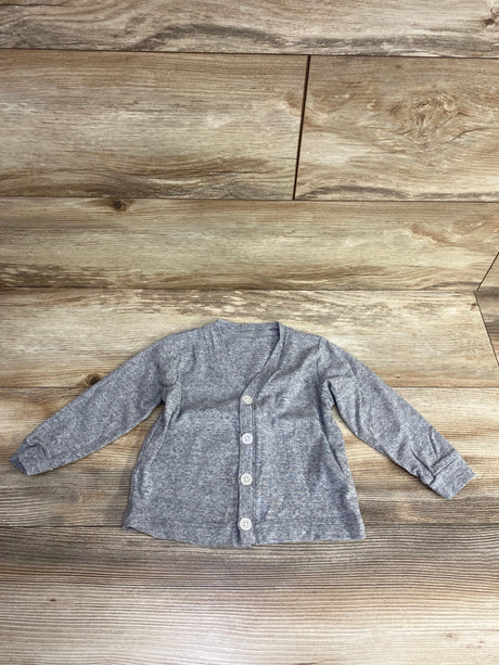 Light gray long-sleeve baby cardigan with buttons on wooden floor background