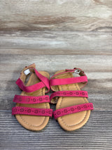Top-down view of Ositos slingback toddler sandals showing three floral-cut pink straps and tan stitched footbed on wood background, size 5C
