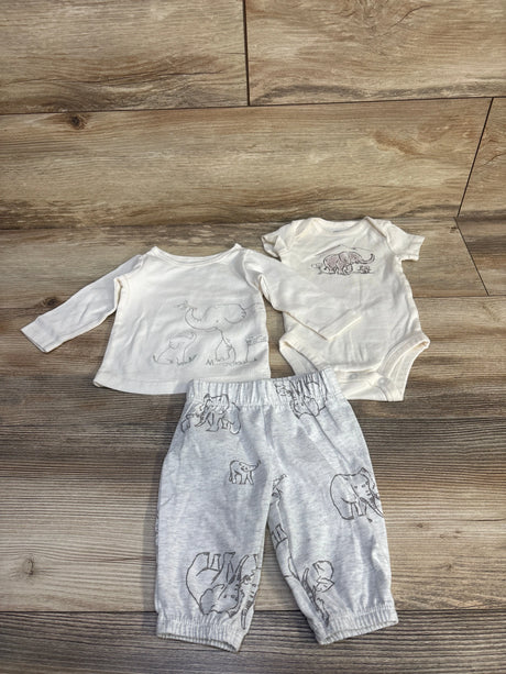 Flat lay of Carter's 3-piece ivory baby bodysuit set with elephant prints on top, bodysuit, and gray pants on wood floor