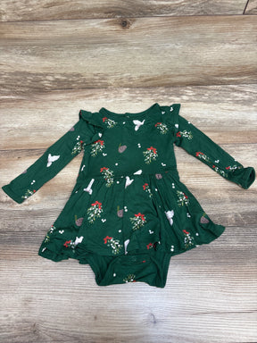 Front view of Kyte Baby Mistletoe Twirl Bodysuit Dress in green with long sleeves, ruffled skirt, and attached bodysuit on wood