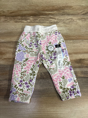 Okie Dokie baby pants size 6 months with soft floral pattern in pink, purple, and green on wooden surface