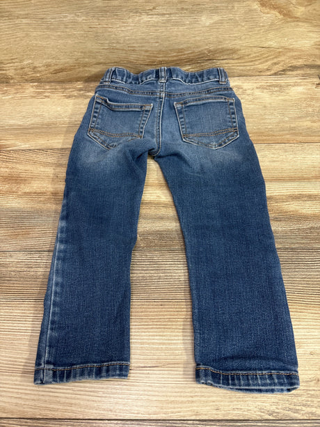 Back view of blue Cat & Jack slim jeans for toddlers size 3T on a wooden background