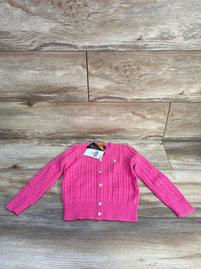 Flat lay of hot pink Polo Ralph Lauren cable-knit cardigan with buttons, embroidered pony logo and tags on light wood floor