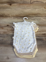 Front view of 3-pack organic baby bodysuits on hanger, white bodysuit with small yellow lemon print over beige and yellow on wood background