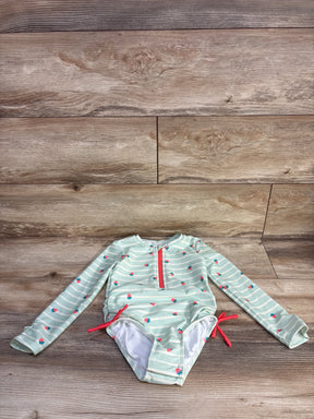 Front view of green girls' long-sleeve rash guard with white stripes and small strawberry print on white background