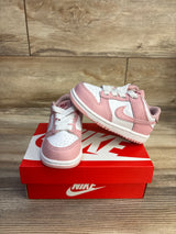 Front and side of toddler Nike Dunk Low Pink Glaze sneakers showing pink overlays, perforated white toe, Swoosh on red box