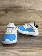Toddler sneakers with white mesh and blue patent accents on wood background