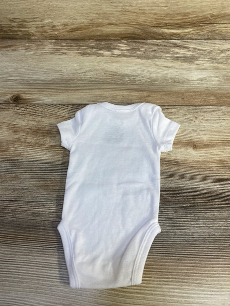 Back view of newborn white Nike bodysuit showing short sleeves and snap closure at the crotch on wood plank background
