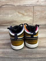 Rear view of toddler Air Jordan 1 Mid SE Wear-Away Taxi sneakers with cracked yellow finish and rainbow lining on wood