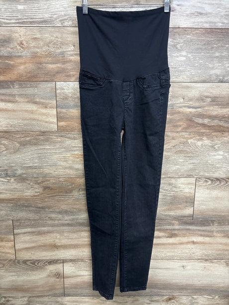 Front view of Monkey Ride maternity black jeans with high stretch belly panel and slim tapered legs against wood background