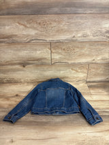 Back view of Children's Place denim jacket size 5T showing faded blue wash, button cuffs, and yoke stitching on wood plank background