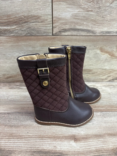 Three-quarter view of Janie & Jack brown quilted riding boots showcasing buckle strap and side zipper on wood flooring