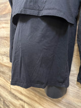 Close-up of black Smallshow maternity long sleeve nursing shirt showcasing layered nursing access panel on wood floor