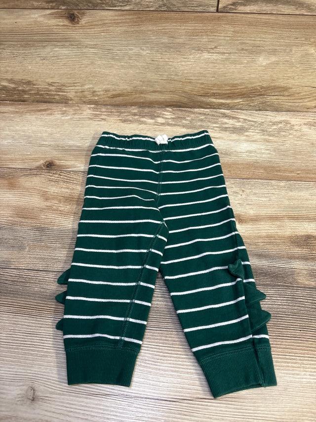 Flat lay of Carter’s green striped baby joggers size 18M showing side ruffles, elastic knot waistband and ribbed cuffs on wood