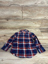 Children's long sleeve blue and red plaid flannel shirt laid flat on wood floor