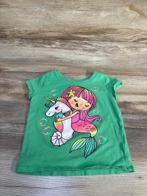 Flat-lay of green Children's Place 2T t-shirt showing a pink-haired mermaid hugging a unicorn graphic, short sleeves on wood background