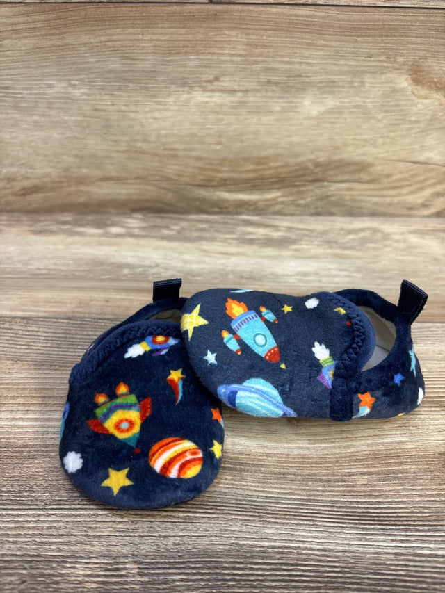 Side view of navy baby slippers size 5C showing plush fabric and colorful rocket and planet print on wood background