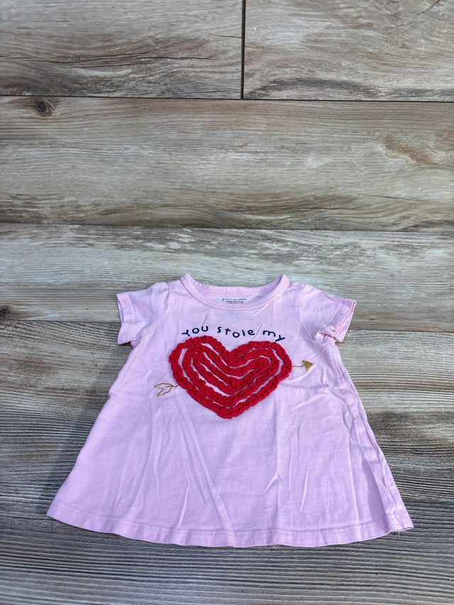 Front view of pink 12M baby tee showcasing red textured heart applique and you stole my text on wood background