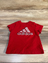 Red Adidas infant t-shirt size 3m featuring the brand logo, laid flat on a wood-grain surface.