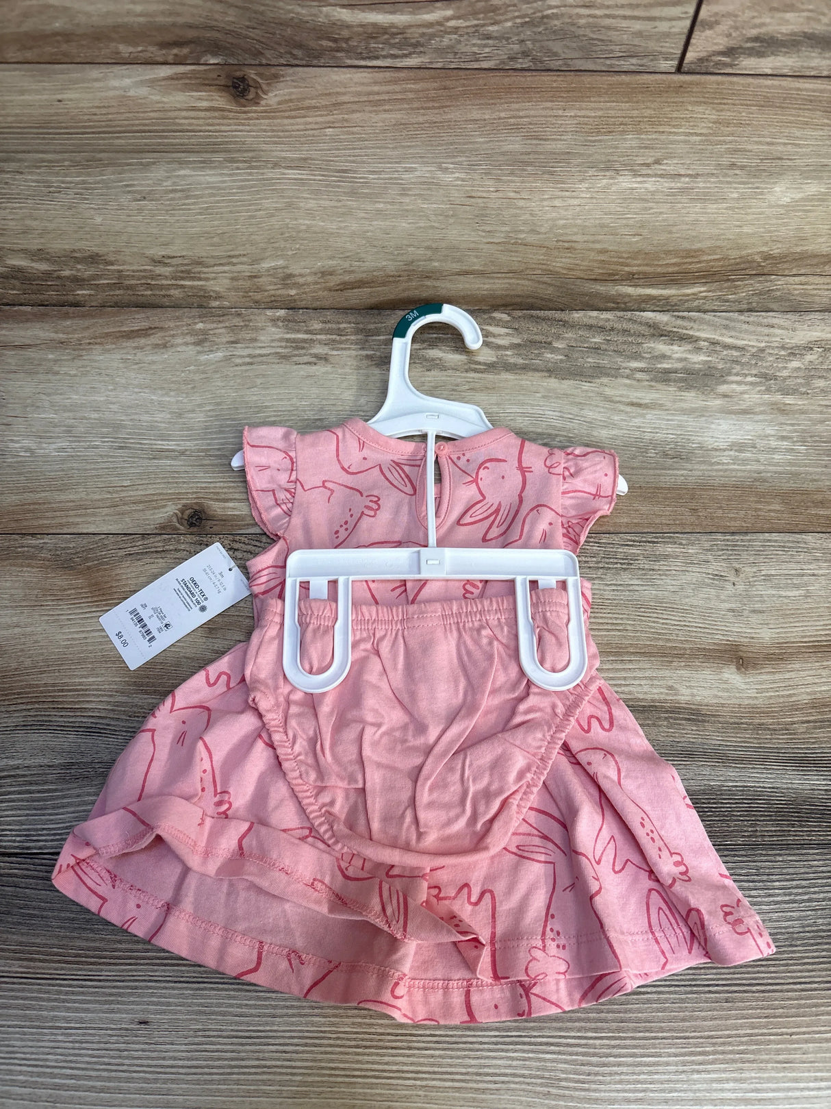 Pink baby dress with bunny print, size 3M, on hanger for resale