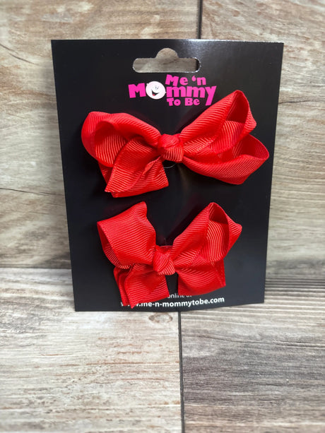 Two red grosgrain hair bows on a Me n Mommy To Be branded black packaging card.