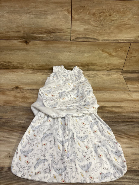Top view of white Halo x Harry Potter SleepSack Swaddle showcasing owl and wizard-themed print on a wood background