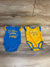 Two baby bodysuits on wooden floor; blue with Los Angeles football print, yellow with heart graphic and ruffled sleeves