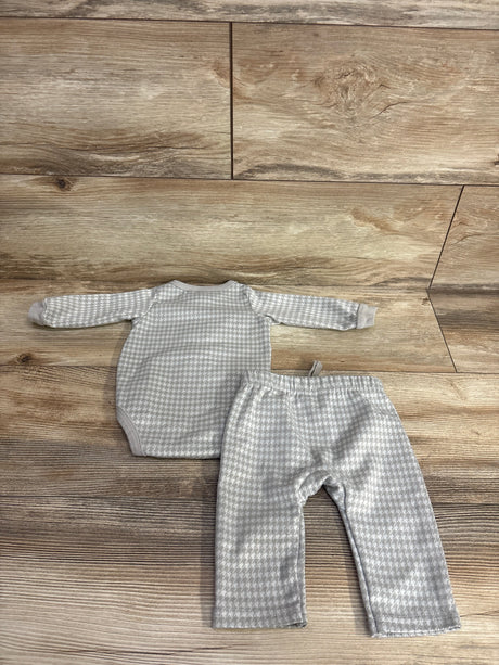 Grey and white houndstooth baby bodysuit and pants set displayed on wood floor